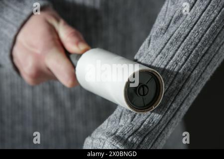 Haarentfernerwalze. Frau, die wiederverwendbare Klamottenreiniger benutzt. Stockfoto