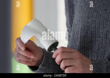 Haarentfernerwalze. Frau, die wiederverwendbare Klamottenreiniger benutzt. Stockfoto