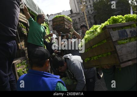 Buenos Aires, Argentinien. April 2024. Eine Gruppe von Menschen händigt Holzkisten mit Obst und Gemüse vor dem argentinischen Kongress in Buenos Aires. Hunderte von Menschen versammeln sich vor dem argentinischen Nationalkongress, um kostenlos verschiedene Früchte, Gemüse und Pflanzen direkt von den landwirtschaftlichen Erzeugern der UTT (Land Workers Union) zu erhalten, die sich aufgrund der Wirtschaftskrise im April in diesem Land befinden. (Foto: Igor Wagner/SOPA Images/SIPA USA) Credit: SIPA USA/Alamy Live News Stockfoto