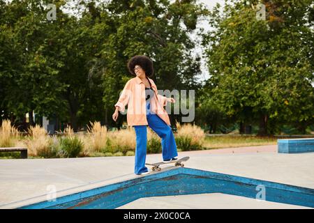 Eine junge Afroamerikanerin mit lockigen Haaren fährt auf einer Rampe in einem Skatepark Skateboard und führt waghalsige Tricks aus. Stockfoto