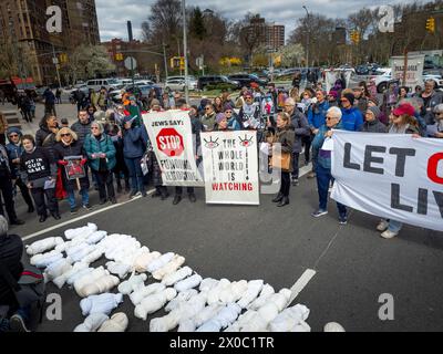 6. April 2024, Brooklyn, Vereinigte Staaten: Eine kleine Gruppe von Demonstranten, die Banner und Plakate halten, betet für Kinder, während sie während einer Pro-Palästina-Demonstration um mehrere Simulationen von toten Kindern herumstehen. Demonstranten versammeln sich auf dem Grand Army Plaza in Brooklyn, um gegen die Ermordung von Kindern in Gaza zu protestieren. Sie schlossen sich den Jewish Elders & Friends für die Ceasefire an, ein Teil der Jewish Voice for Peace. Der Fokus lag darauf, Senator Schumer dazu zu drängen, den Völkermord mit der Slogan "Wir fordern Aktion, nicht leere Worte" einzustellen. Die Route führte durch den Markt von farmerâ, um die Hungersnot zu beleuchten. Stockfoto