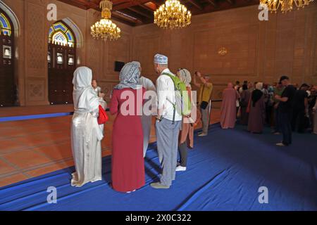 Sultan Qaboos Grand Mosque Touristen stehen auf blauem Cover, um den Gebetsteppich im Gebetsraum der Frau Muscat Oman zu schützen Stockfoto