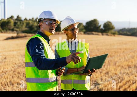 Ingenieure passen den Betrieb einer Windturbine mit einem Laptop an. Stockfoto
