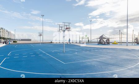 Povoa de Varzim, Porto, Portugal - 22. Oktober 2020: Basketballplatz und Kinderspielplatz am Meer an einem Herbsttag Stockfoto