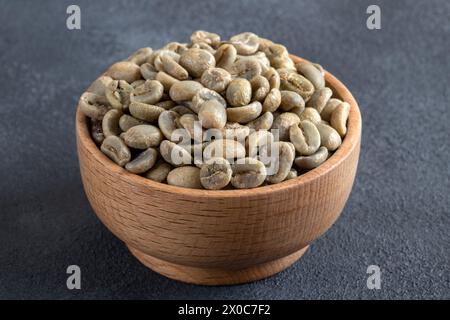 Eine Schüssel voller grüner Kaffeebohnen auf schwarzem Hintergrund Stockfoto