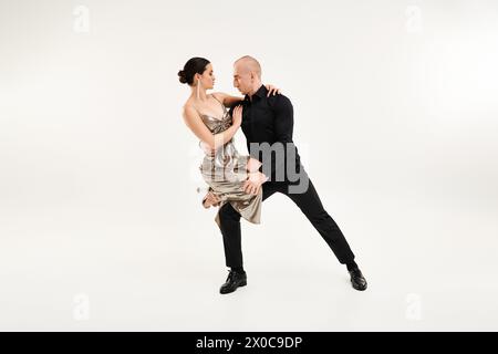 Ein junger Mann und eine Frau tanzen akrobatisch zusammen in perfekter Synchronisation vor weißem Studio-Hintergrund. Stockfoto