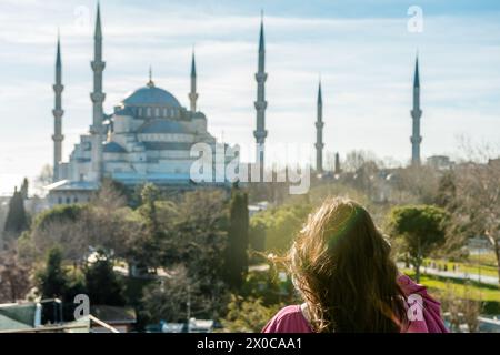 Eine junge Frau, die auf der faszinierenden Blauen Moschee in Istanbul, Türkei, schaut. Stockfoto
