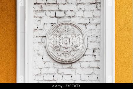 Klassische Architekturdetails, weißes rundes Dekorationselement auf Backsteinwand, Vorderansicht Stockfoto