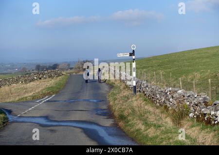 Zwei Männer, die die ruhige Country Lane (Old Road) von Clapham nach Ingleton in der Nähe von Cold Cotes im Yorkshire Dales National Park, England, befahren Stockfoto