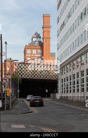 Eine Seitenstraße im Zentrum von Manchester, Großbritannien, mit Blick auf eine Eisenbahnbrücke und die alte Cook Street Brewery Stockfoto