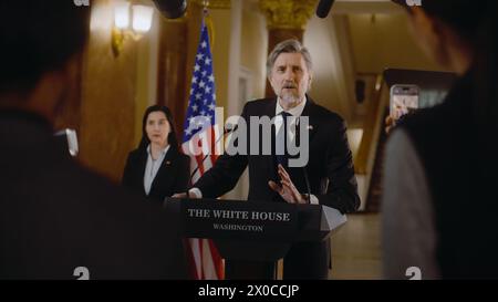 Der Präsident der Vereinigten Staaten spricht während der Pressekonferenz eine politische Rede. Minister spricht mit Journalisten im Weißen Haus, gibt Interview für die Medien. Amerikanische Fahnen im Hintergrund. Stockfoto