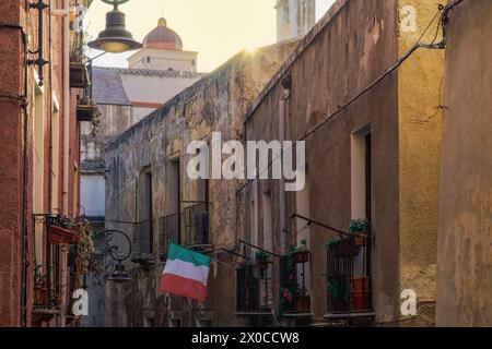 Cagliari Zitadellengasse mit traditionellen Gebäuden mit eisernen Balkonen und italienischer Flagge, die auf Sardinien, Italien, winkt. Stockfoto