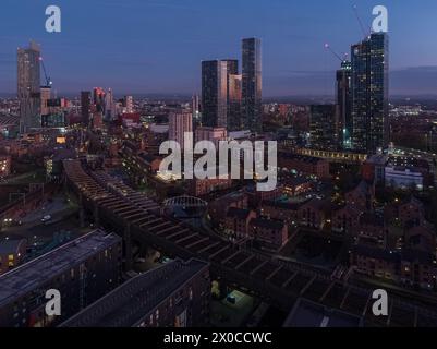 Luft-/Drohnenfotografie mit Blick über Castlefield im Vordergrund und das größere Stadtzentrum von Manchester in der Abenddämmerung Stockfoto