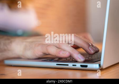 Die menschliche Hand drückt den ein-/Ausschalter auf der Laptop-Tastatur Stockfoto