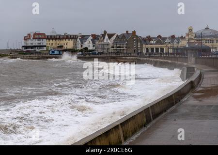 Bei rauem Küstenwetter krachen die Frühlingsgezeiten an der Porthcawl Promenade in Südwales an. Stockfoto