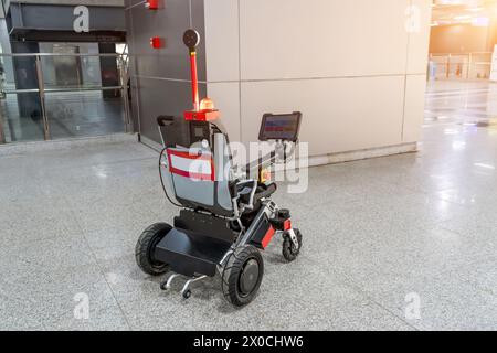 Moderner technologischer Rollstuhl mit Fernbedienung, Roboter mit künstlicher Intelligenz, für die Beförderung von Passagieren auf Flughäfen oder Bahnhöfen Stockfoto