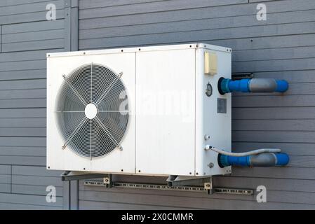 Verflüssigungseinheit von Klimaanlagen. Verflüssigungseinheit an der grauen Wand montiert Stockfoto