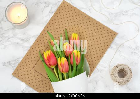 Getränke in blauen Gläsern, dekoriert mit Blumen und Zitronenscheiben. Draufsicht, über Blattschatten. Stockfoto