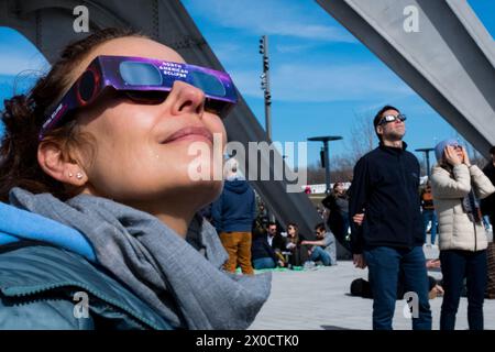 Frau, die die Sonnenfinsternis in Montreal, Kanada, beobachtet, April 2024 Stockfoto