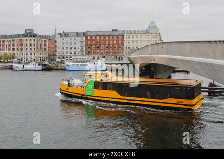 Gelber Bootsbus, der unter der Inderhavnsbroen-Brücke vorbeifährt, Kopenhagen Dänemark April 2024 Stockfoto