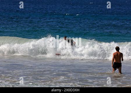 Zwei Männer genießen die Wellen am Piedra Playa Surfstrand, El Cotillo, Fuerteventura. Vom Februar 2024 Stockfoto