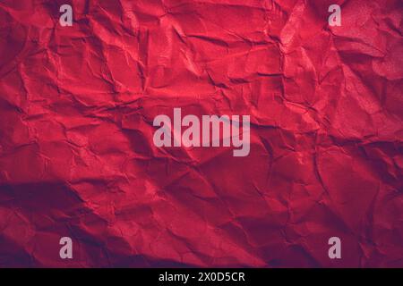 Roter Papierstrukturhintergrund. Zerknitterter Hintergrund aus rotem Papier mit abstrakter Form. Stockfoto