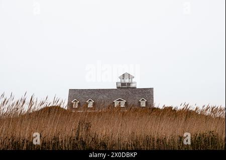 Oregon Inlet Life Saving Station hinter Dünengras vor einem weißen Himmel Stockfoto