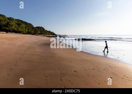 Junge, Tourist, mit einer Angelrute in der Hand, die Strand Playa Montezuma in der Nähe von Montezuma Dorf an einem sonnigen Sommertag, Nicoya Halbinsel, Costa rica Stockfoto