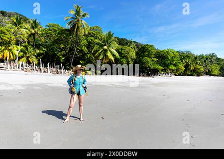 Frau mit Strohhut, Tourist, Erkundung an einem Strand Playa Montezuma in der Nähe von Montezuma Dorf an einem schönen sonnigen Sommertag, Costa rica Stockfoto