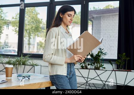 Eine Geschäftsfrau hält selbstbewusst ein Klemmbrett in einem modernen Büro und verkörpert Effizienz und Professionalität. Stockfoto