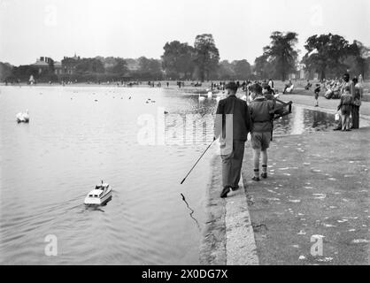 London, England. Jungs mit einem Modellboot auf dem Round Pond in Kensington Gardens, 1951 Stockfoto