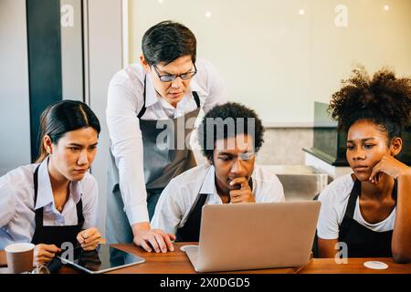 Jungunternehmer im Coffee-Shop sind stolz auf Freude und Spaß. Die Planung der Verwaltung mit einem Notebook bringt Stockfoto