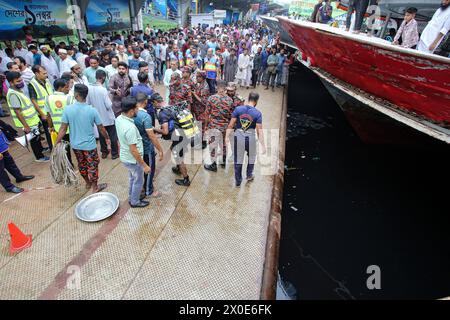 Mindestens 5 Tote bei einem Schiffsunfall in Dhaka Feuerwehrleute, Sicherheitsbeamte und örtliche Menschen versammeln sich nach einem Schiffsunfall am Sadarghat Schiffsterminal in Dhaka, Bangladesch am 11. April 2024. Nach Angaben der Flusspolizei wurden mindestens fünf Menschen getötet, nachdem ein Schiffseil bei einem Parkversuch von einem anderen Schiff am Sadarghat Schiffsterminal in Dhaka abgerissen wurde. Dhaka Dhaka Bezirk Bangladesch Copyright: XHabiburxRahmanx Stockfoto