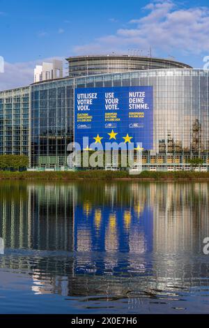 Europawahl 2024 am EU-Parlament in Straßburg prangt ein Aufruf zur Wahlbeteiligung bei den bevorstehenden Europawahlen Anfang Juni, mit den Botschaften NUTZE DEINE STIMME auf Deutsch, VERWENDEN SIE IHRE STIMME auf Englisch und UTILISEZ VOTRE VOIX auf Französisch. Das riesige Plakat zielt darauf ab, alle Europäer dazu auffordern, im Juni ihre Stimme abgeben, sei es per Briefwahl oder im Wahllokal. Vom 22. bis zum 25. April wird im EU-Parlament in Straßburg die letzte Plenarsitzung vor der Europawahl stattfinden, bei der EU-Abgeordneten zusammenkommen. Straßburg Robertsau Sud Ouest Bas-Rhin Frankrei Stockfoto