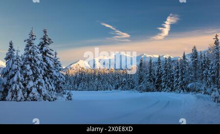 Die niedrige Wintersonne erleuchtet die Chugach Mountains entlang einer Straße im Südwesten Alaskas. Stockfoto