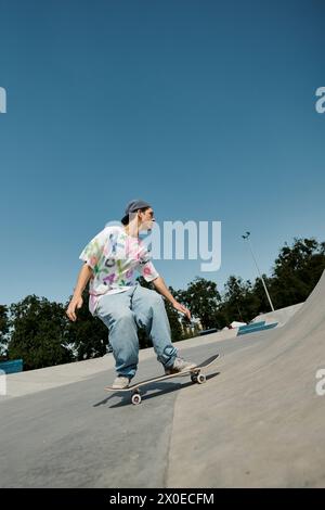 Ein junger Skaterjunge reitet an einem Sommertag furchtlos an einer Rampe in einem belebten Outdoor-Skatepark mit seinem Skateboard entlang. Stockfoto