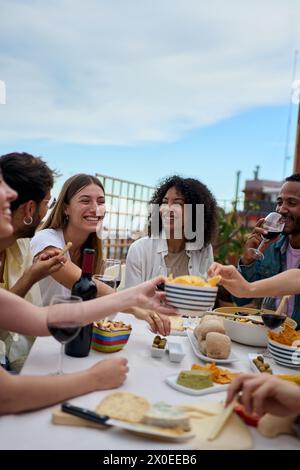 Gruppe von multiethnischen jungen Freunden, die sich auf dem Dach versammeln Stockfoto