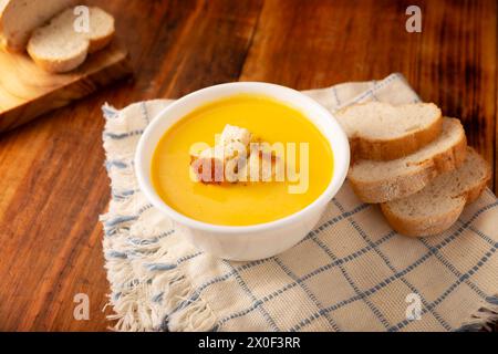 Hausgemachte Karotten- und Kürbiscremesuppe. Einfaches, nahrhaftes und gesundes Rezept. Serviert in einer weißen Schüssel mit Brotcroutons. Perfekt für jeden Tag Stockfoto