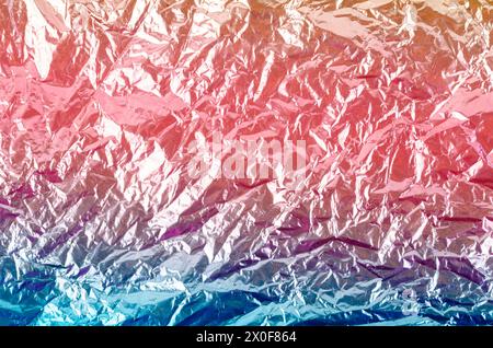 Farbenfroher Folienhintergrund mit glänzender zerknitterter Oberfläche für Textur als Hintergrund. Stockfoto