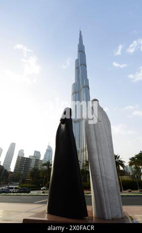 Der Burj Khalifa Wolkenkratzer und die arabische Paarstatue in der Innenstadt von Dubai, VAE. Stockfoto