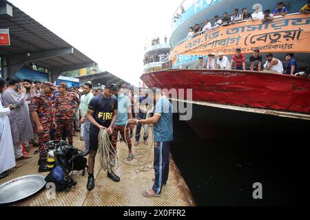 Dhaka, Bangladesch. April 2024. Feuerwehrleute, Sicherheitsbeamte und örtliche Menschen versammeln sich nach einem Schiffsunfall am Schiffsterminal Sadarghat in Dhaka, Bangladesch, 11. April 2024. Nach Angaben der Flusspolizei wurden mindestens fünf Menschen getötet, nachdem ein Schiffseil bei einem Parkversuch von einem anderen Schiff am Sadarghat Schiffsterminal in Dhaka abgerissen wurde. Foto: Habibur Rahman/ABACAPRESS.COM Credit: Abaca Press/Alamy Live News Stockfoto