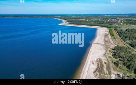 Cottbus, Deutschland. April 2024. Die Cottbuser Ostsee entsteht im ehemaligen Braunkohlebergwerk Cottbus-Nord (Luftaufnahme mit Drohne). Der 19 Quadratkilometer große See soll zum größten künstlichen Gewässer Deutschlands werden. Die Überschwemmungen begannen Mitte April 2019 im ehemaligen Tagebau Cottbus-Nord. Die Lausitz Energie Bergbau AG (Leag) lässt Wasser von der Spree über den Hammergraben in das Tagebauloch für die Überschwemmung fließen. Quelle: Patrick Pleul/dpa/Alamy Live News Stockfoto