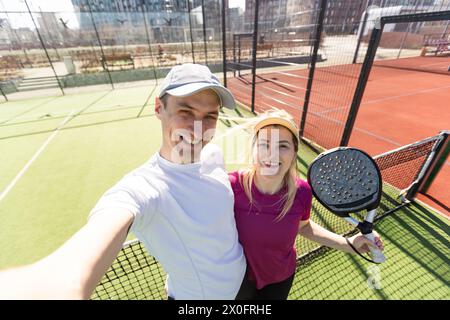 Paddle-Tennis-Team von Frauen und Männern, die im Weitwinkelbild posieren Stockfoto