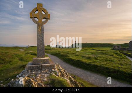 Ein keltisches Kreuz auf Llanddwyn, entlang der Küste von Anglesey, Wales, in der Nähe von Newborough Beach. Es ist Sonnenuntergang Stockfoto