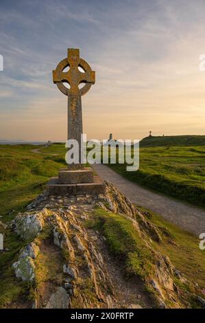 Ein keltisches Kreuz auf Llanddwyn, entlang der Küste von Anglesey, Wales, in der Nähe von Newborough Beach. Es ist Sonnenuntergang Stockfoto