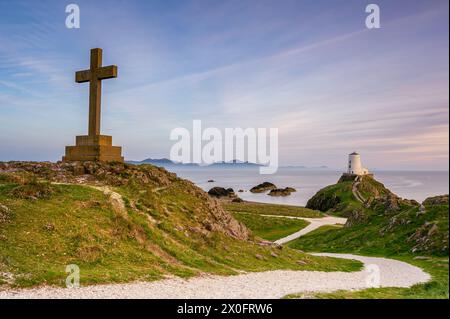Ynys Llanddwyn Lighthouse und ein religes Kreuz, bei Sonnenuntergang an einem Sommertag. Nordwales, Anglesey Stockfoto