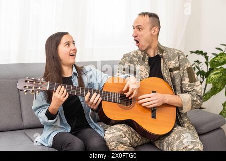 Ein Veteran und seine Tochter spielen Gitarre Stockfoto