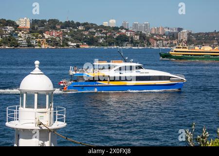 Manly Ferry die grüne und goldene MV Freshwater und die Manly Schnellfähre im Hafen von Sydney fahren vorbei an Bradleys Head und seinem historischen Leuchtturm Sydney Stockfoto