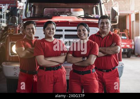 Ein lächelndes Team von männlichen und weiblichen Feuerwehrleuten in der Feuerwache Stockfoto