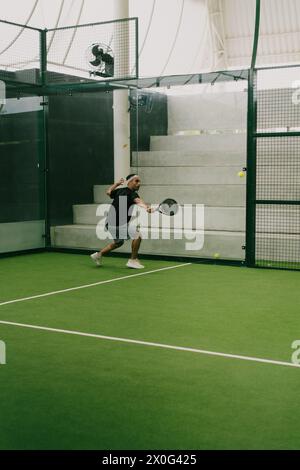 Mann spielt Padel-Tennis auf einem Hallenplatz, Bali. Stockfoto